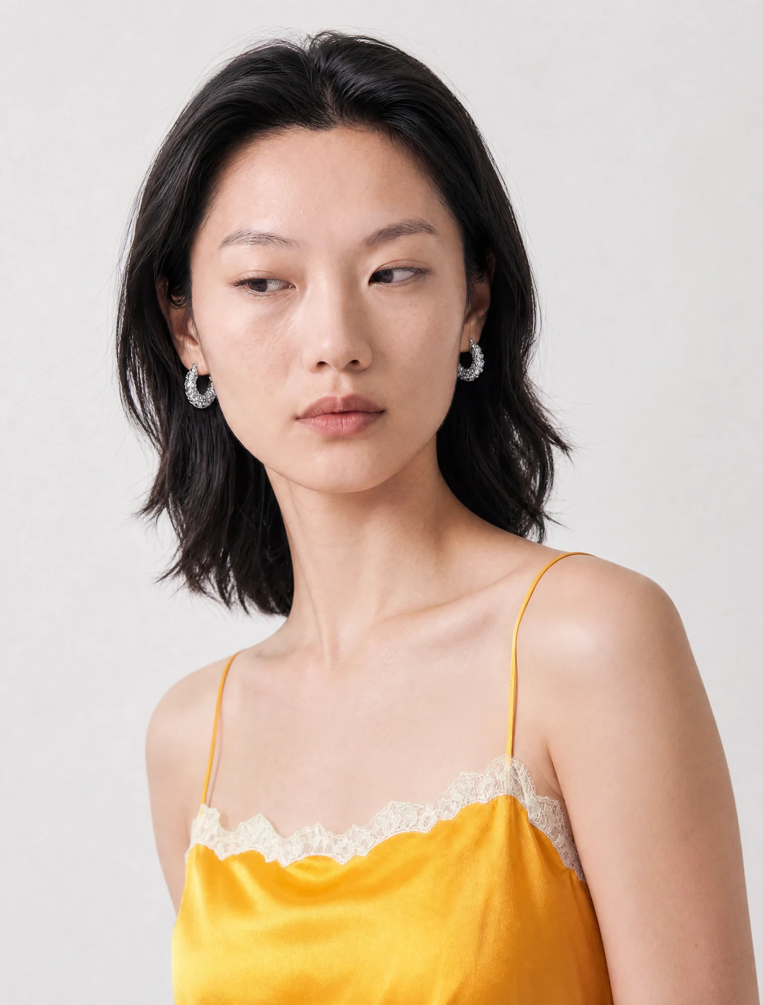 AI-generated on-model image: yellow lace-trim camisole, close-up portrait