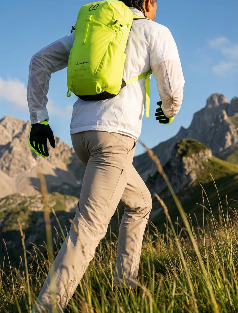 AI-generated on-model image: technical outerwear and a backpack shot running on a trail