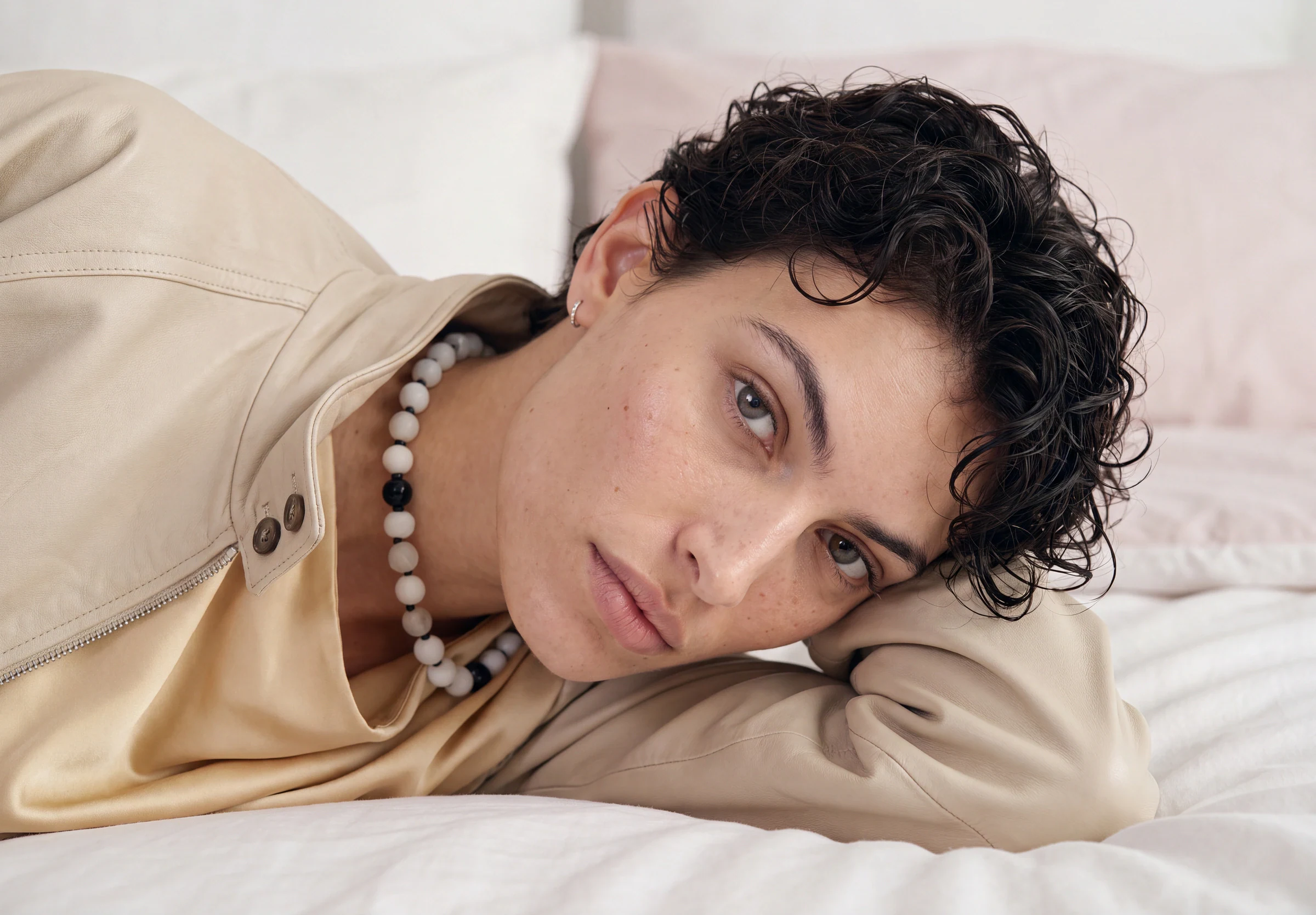 AI-generated on-model image: an oversized coat photographed on a bed set, wide frame