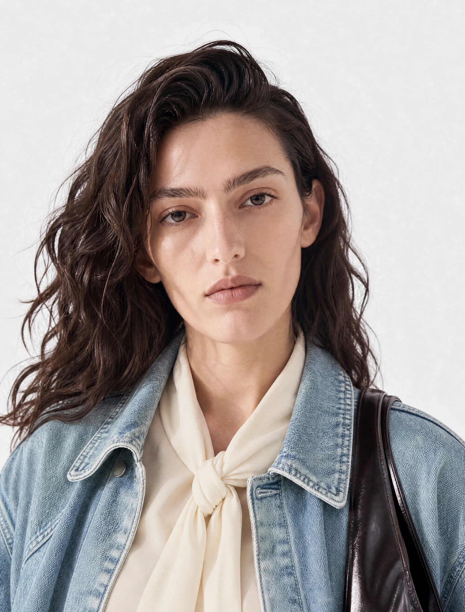 AI-generated on-model image: denim jacket over a tie-neck blouse, close-up portrait