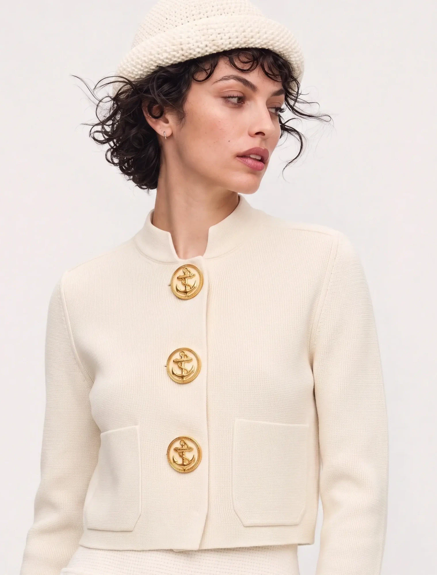 AI-generated on-model image: cream gold-button jacket with a knit hat, close-up portrait