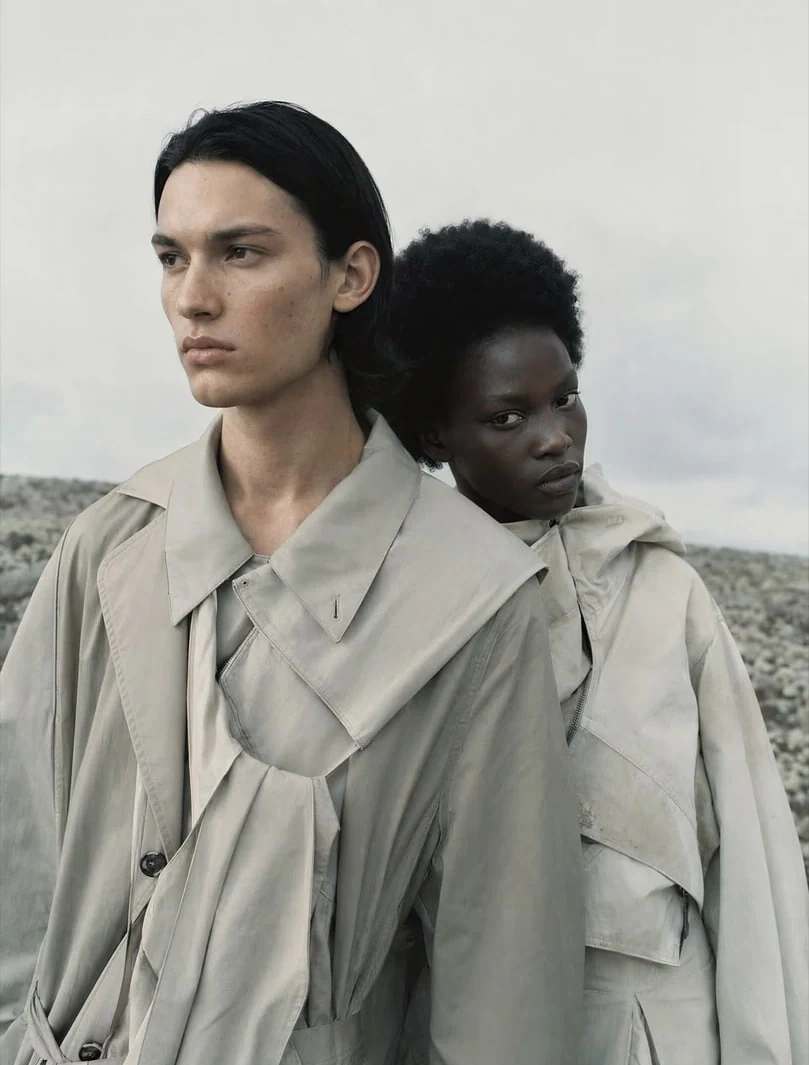 AI-generated on-model image: two models in layered trench coats on location