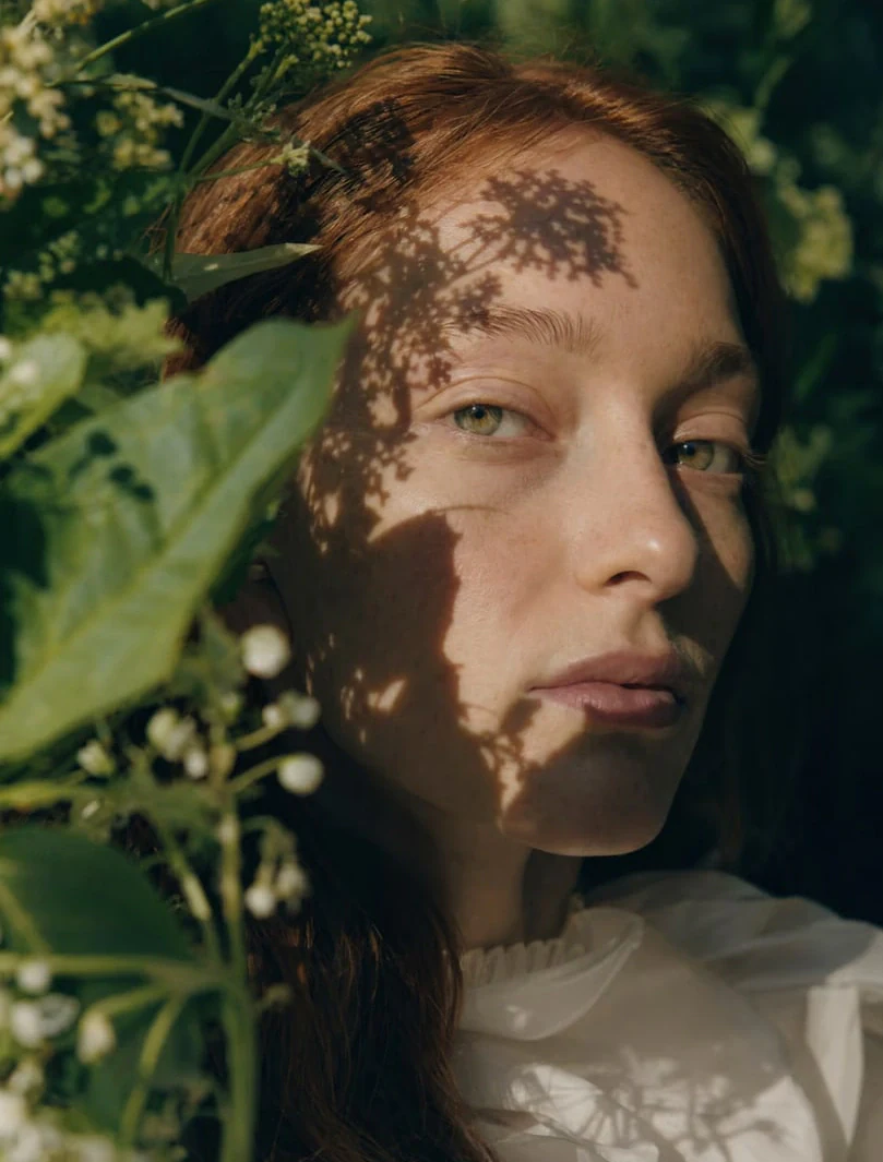 AI-generated on-model image: close-up portrait in dappled daylight
