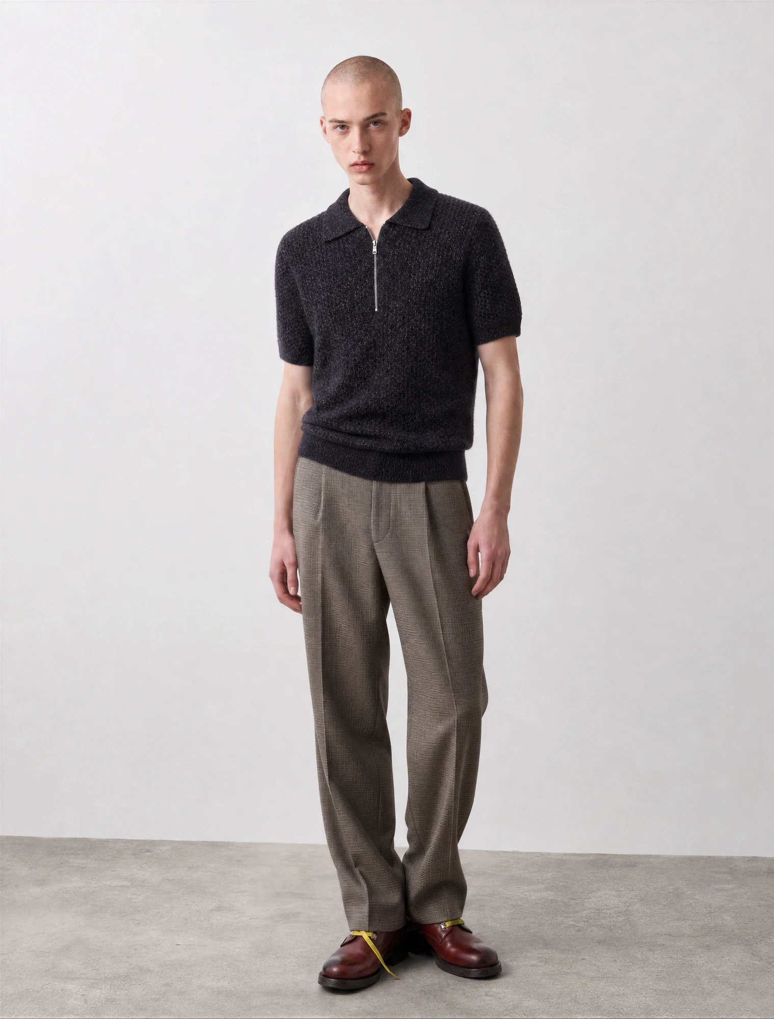 AI-generated on-model image: textured knit polo and tailored trousers on a male model