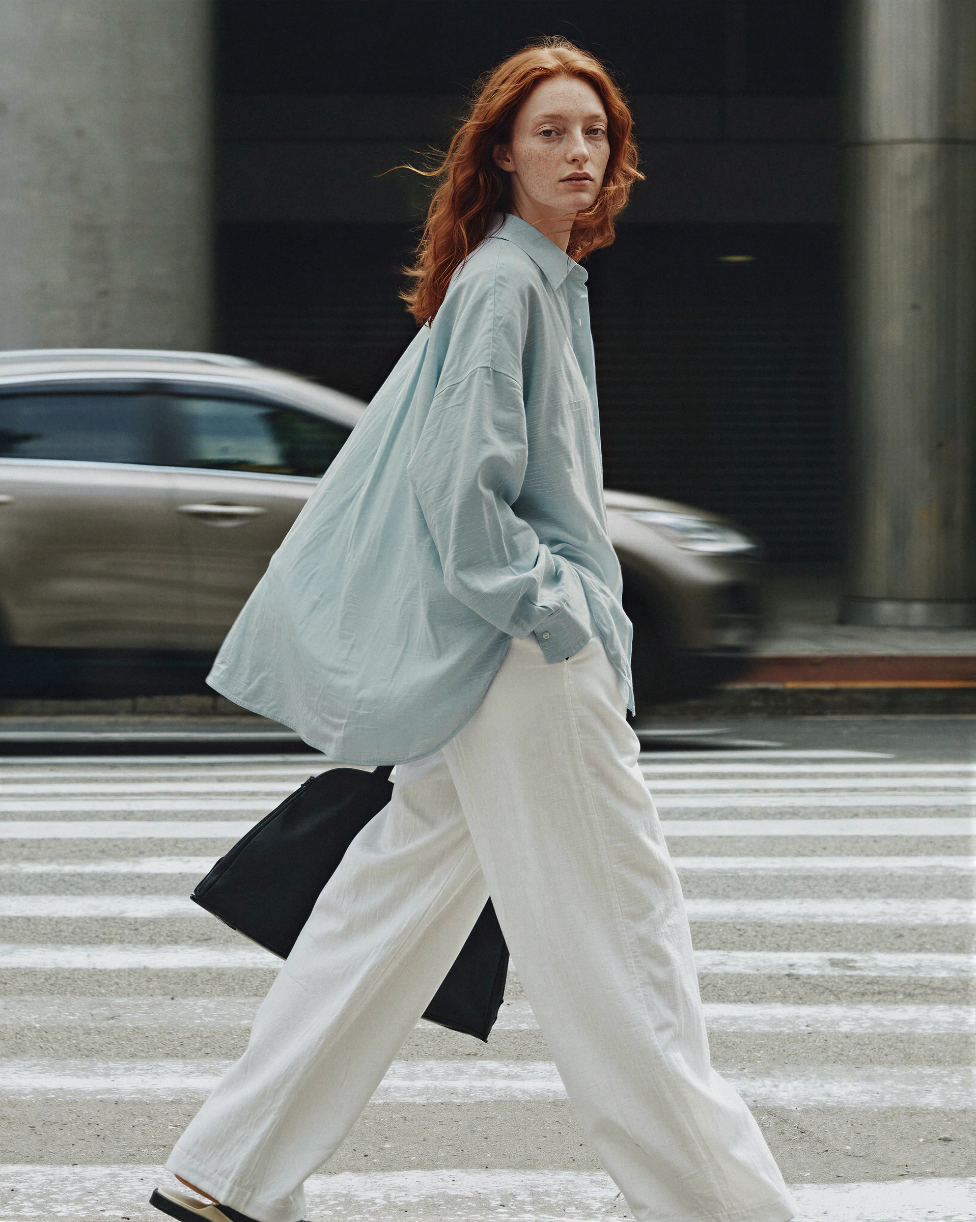 Oversized oxford shirt on the same AI model in a street scene